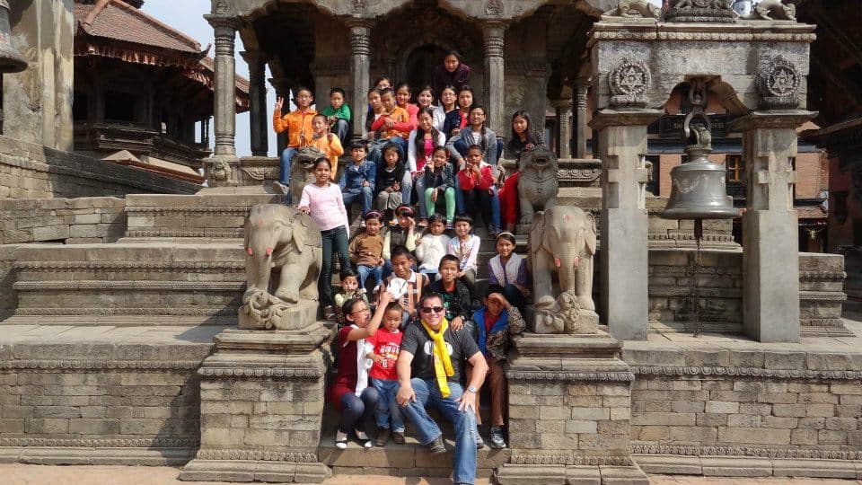 Aaron Cuha with children at a temple in Nepal